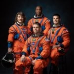 NASA Artemis II astronauts standing in flight suits