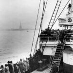 Immigrants aboard a ship approaching the Statue of Liberty