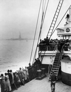 Immigrants aboard a ship approaching the Statue of Liberty