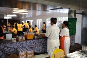School cafeteria workers serving breakfast to students