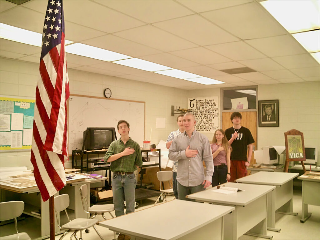 Students reciting the Pledge of Allegiance to the American flag