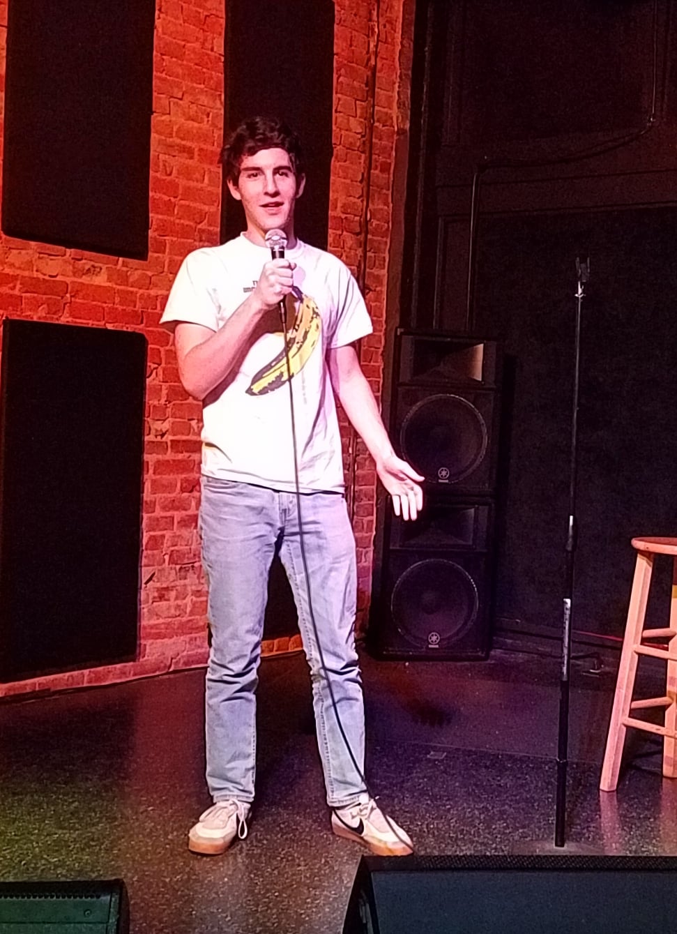 Stand-up comedian holding a microphone on stage